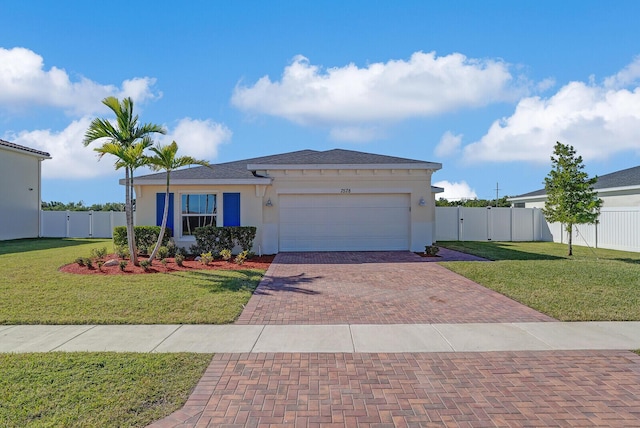 view of front of home with decorative driveway, an attached garage, a front lawn, and fence