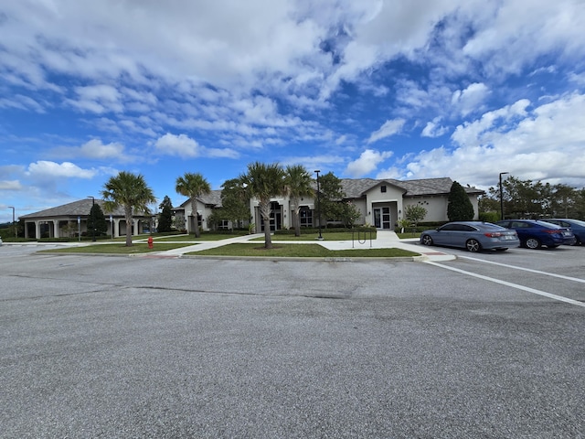 view of front facade featuring a residential view, a front lawn, and stucco siding