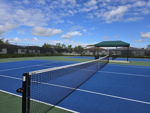 view of tennis court featuring fence and community basketball court