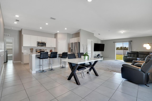 dining room with light tile patterned floors and lofted ceiling