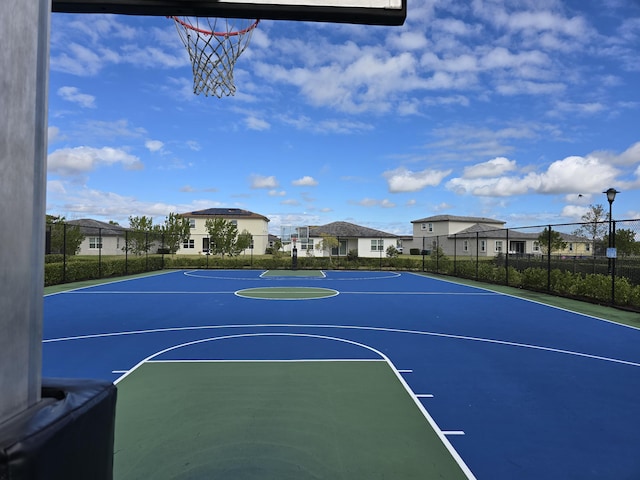 view of basketball court with community basketball court, fence, and a residential view