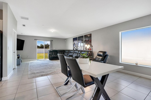 dining area with light tile patterned floors, visible vents, and baseboards