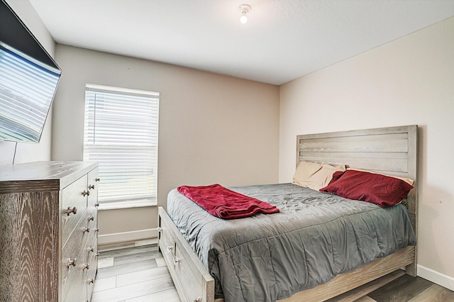 bedroom featuring baseboards and light wood-style floors