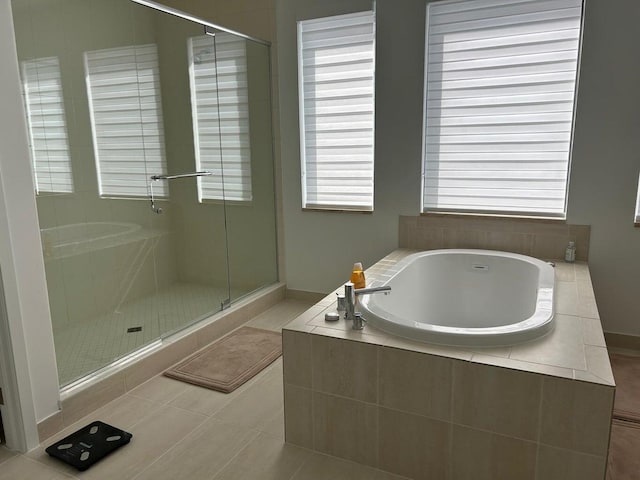 bathroom featuring separate shower and tub, tile patterned flooring, and a wealth of natural light