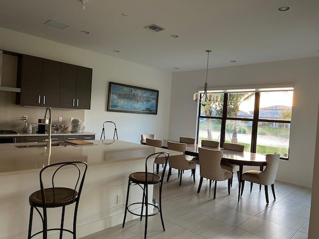 kitchen with decorative light fixtures, a kitchen breakfast bar, plenty of natural light, sink, and a chandelier