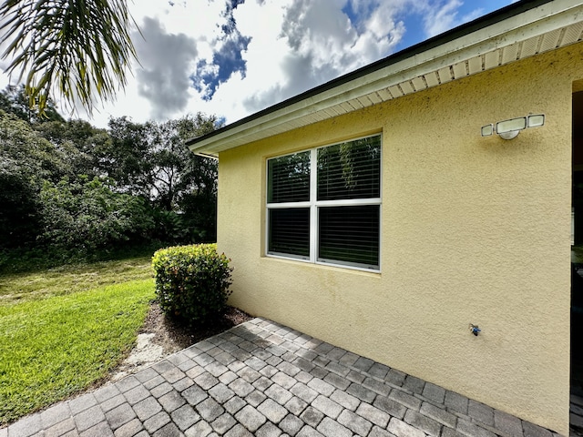 view of side of home featuring a patio and stucco siding