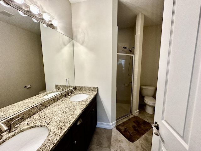 bathroom featuring tile patterned flooring, a shower stall, and a sink