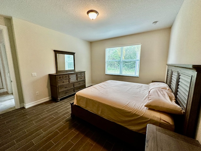 bedroom featuring a textured ceiling and dark hardwood / wood-style floors