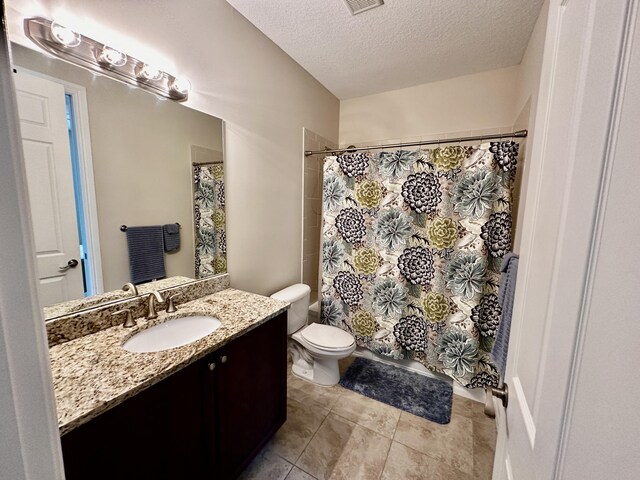 empty room with light tile patterned floors and a textured ceiling