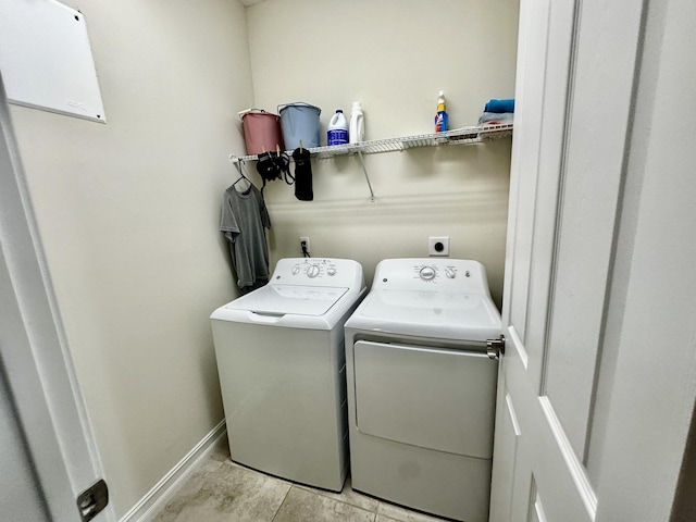 washroom featuring washer and dryer, laundry area, and baseboards