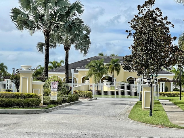 view of street with curbs, a gated entry, and a gate