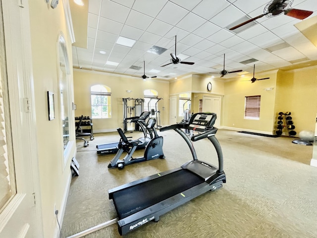 exercise room featuring ornamental molding, a ceiling fan, a paneled ceiling, and baseboards