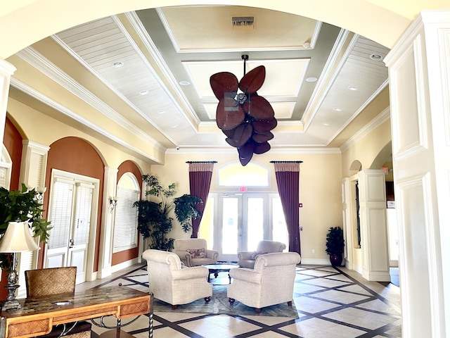 living area featuring visible vents, baseboards, french doors, ornate columns, and crown molding