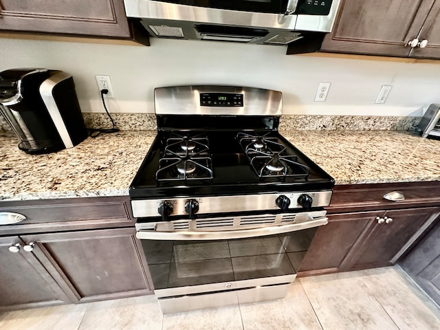 kitchen featuring light stone countertops, appliances with stainless steel finishes, and dark brown cabinetry