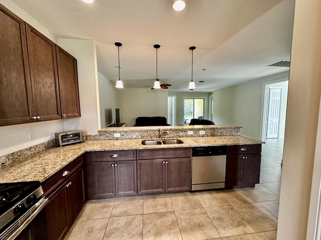 kitchen with stainless steel appliances, a peninsula, a sink, open floor plan, and light stone countertops