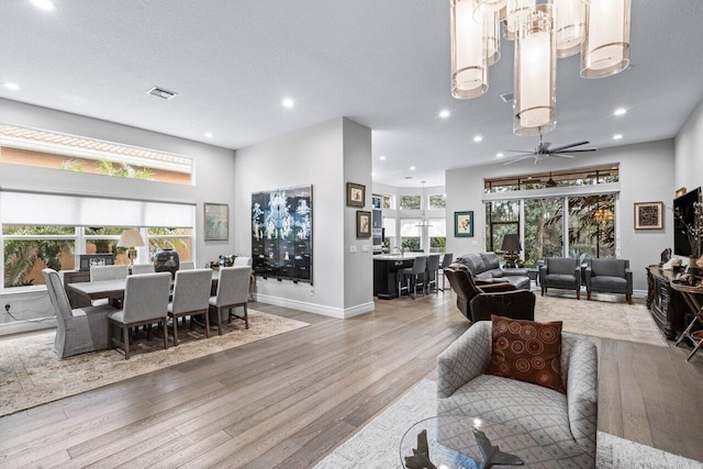 living room with a textured ceiling, plenty of natural light, hardwood / wood-style flooring, and ceiling fan