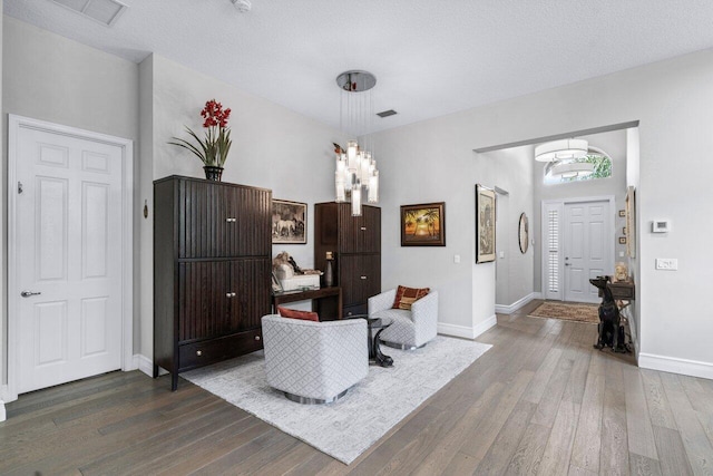 living area with dark hardwood / wood-style flooring and a textured ceiling