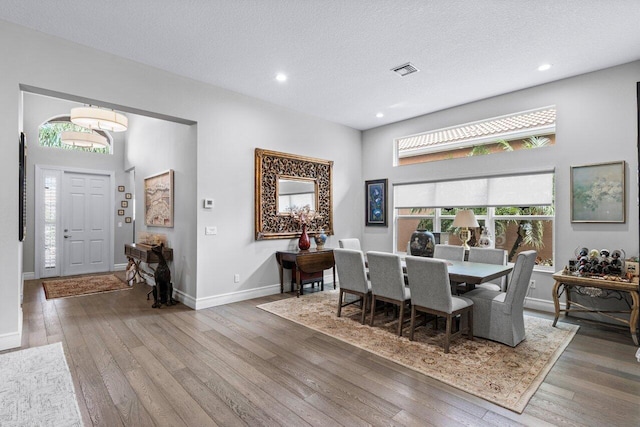 dining area featuring a textured ceiling and dark hardwood / wood-style floors