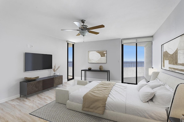 bedroom featuring access to exterior, expansive windows, light hardwood / wood-style flooring, and ceiling fan