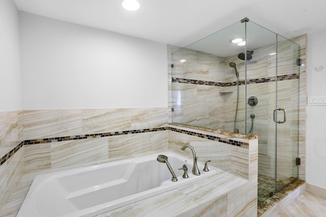 bathroom featuring shower with separate bathtub