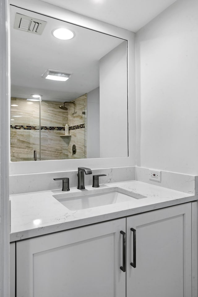 bathroom with vanity and a shower with door