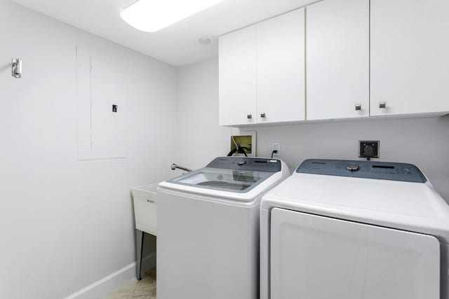 clothes washing area featuring electric panel, separate washer and dryer, and cabinets