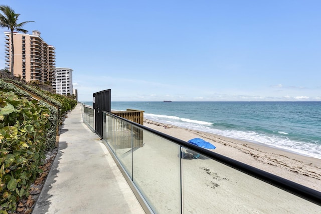 balcony with a water view and a view of the beach