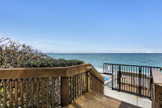 wooden deck featuring a view of the beach and a water view