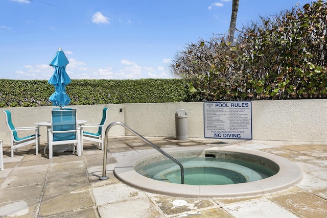 view of swimming pool featuring a hot tub