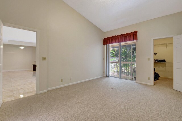 spare room featuring a towering ceiling and carpet floors