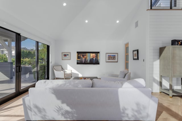 living room with high vaulted ceiling, light parquet floors, and french doors