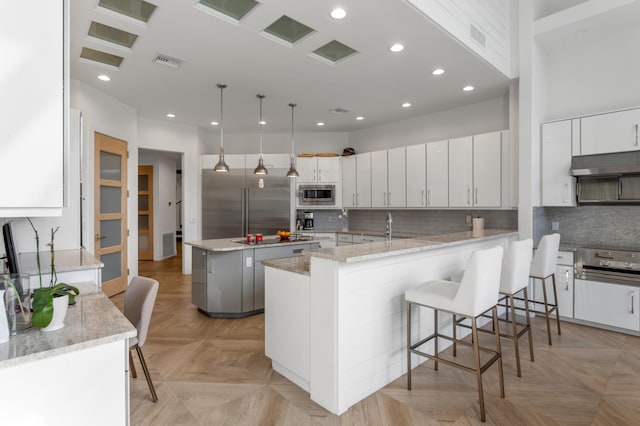 kitchen featuring stainless steel appliances, white cabinets, and a kitchen island