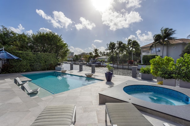 view of pool featuring a patio and an in ground hot tub