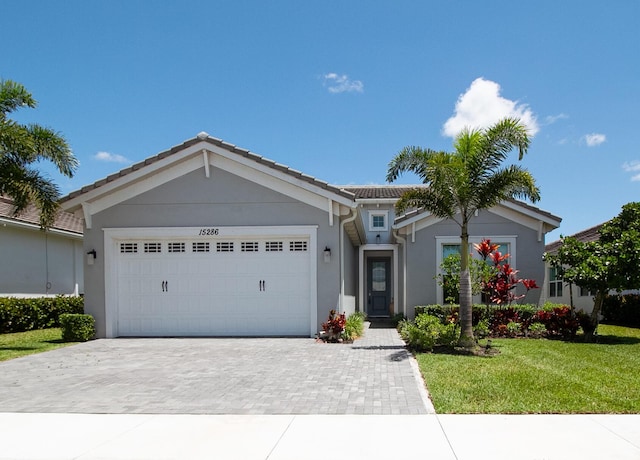 single story home with a garage and a front yard