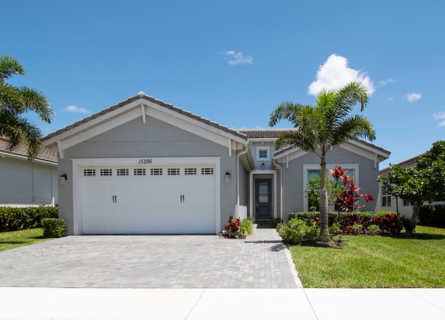 ranch-style house featuring a garage and a front yard