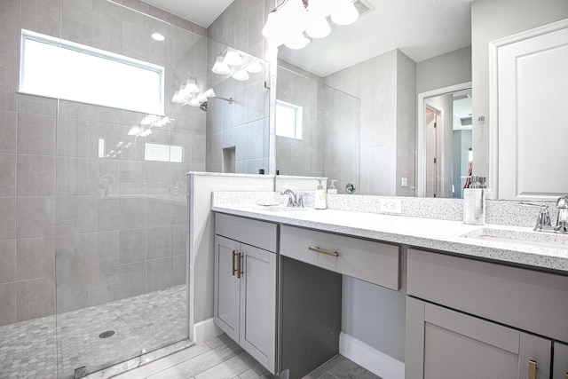 bathroom with vanity and a tile shower