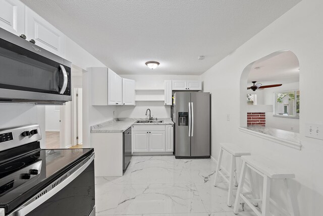 kitchen featuring white cabinetry, sink, a textured ceiling, and appliances with stainless steel finishes