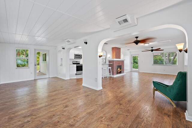 kitchen featuring kitchen peninsula, appliances with stainless steel finishes, a breakfast bar, light hardwood / wood-style floors, and white cabinetry