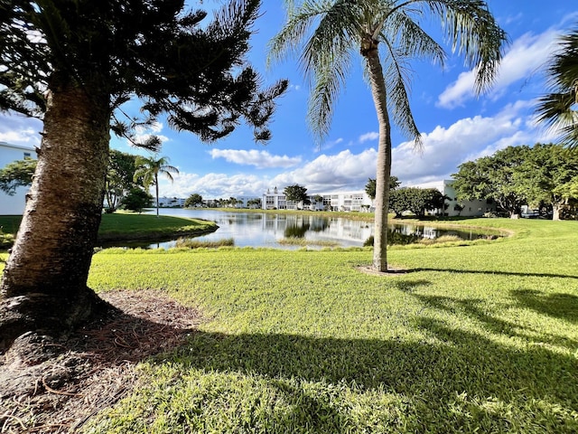 view of green lawn featuring a water view
