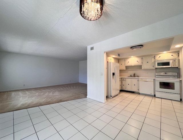 kitchen featuring white appliances, light carpet, a sink, light countertops, and baseboards