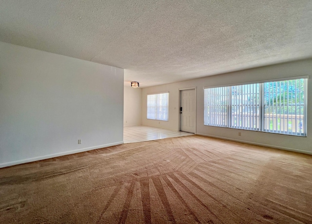 unfurnished living room with a textured ceiling and light colored carpet