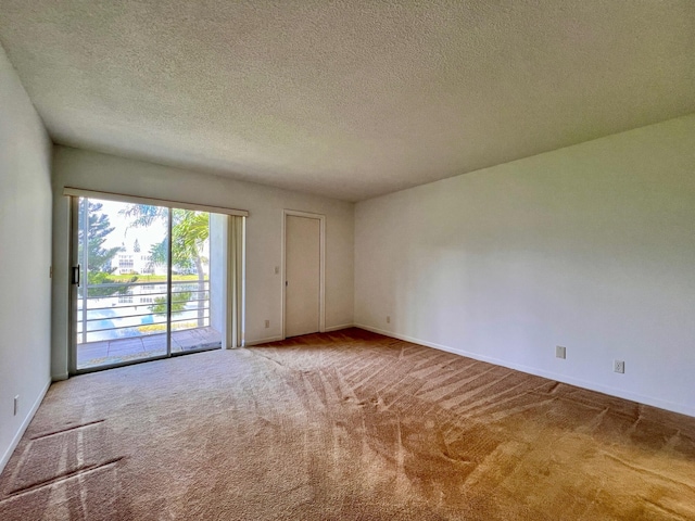 unfurnished room featuring carpet floors and a textured ceiling