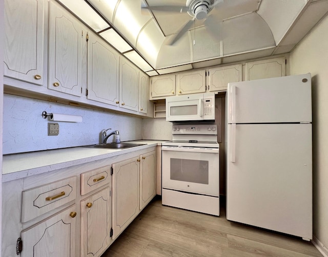 kitchen featuring light wood-type flooring, white appliances, sink, and backsplash