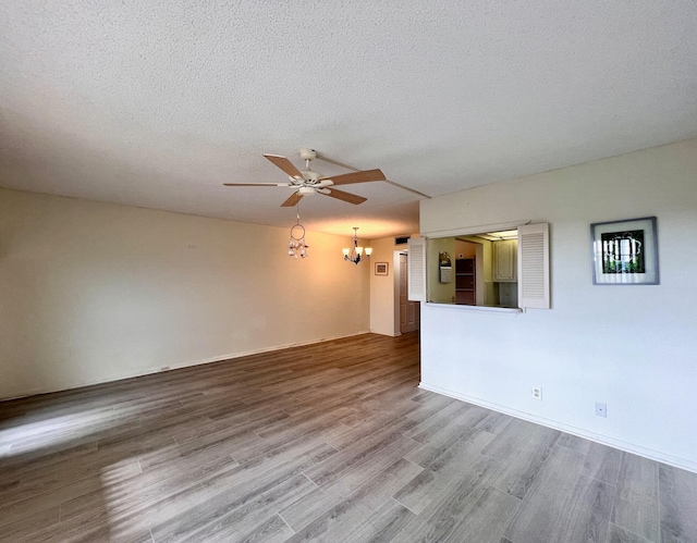 unfurnished room with a textured ceiling, hardwood / wood-style flooring, and ceiling fan with notable chandelier