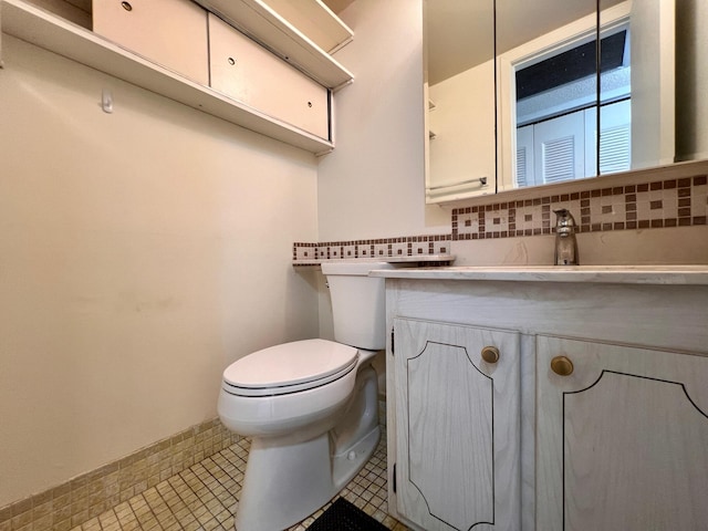 bathroom with vanity, tile patterned floors, toilet, and decorative backsplash