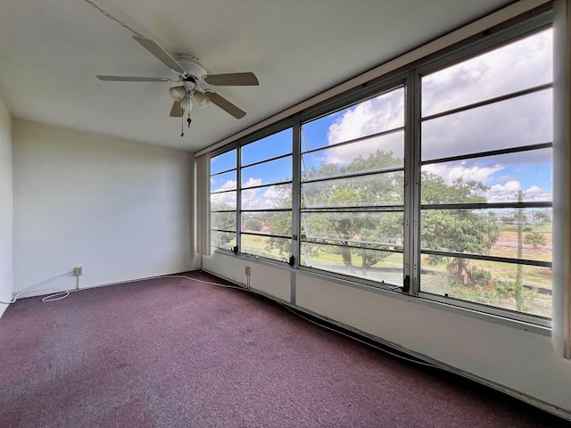 unfurnished sunroom featuring ceiling fan