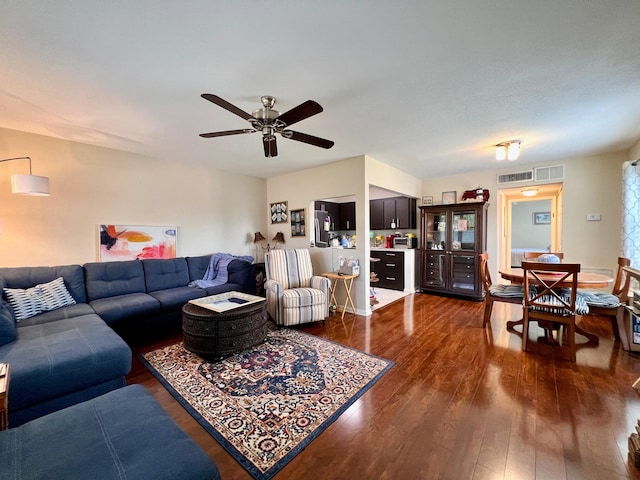 living room with ceiling fan and dark wood-type flooring