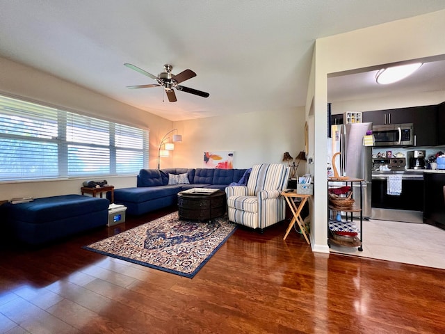 living room featuring ceiling fan and dark hardwood / wood-style flooring