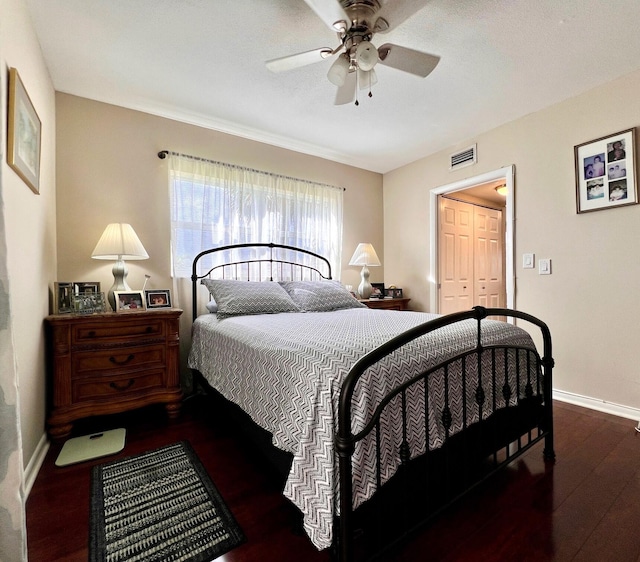 bedroom with ceiling fan, dark wood-type flooring, and a closet