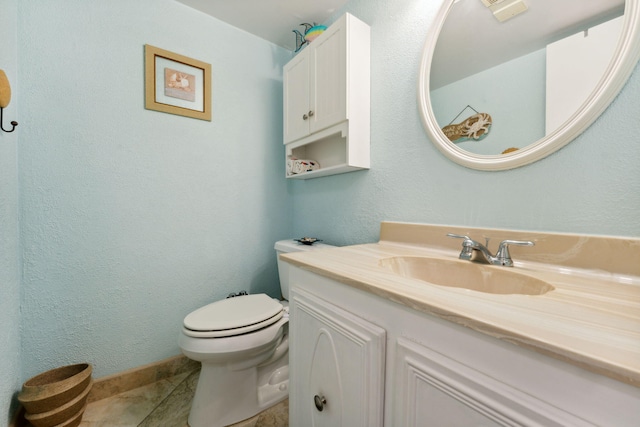 bathroom with tile patterned flooring, vanity, and toilet